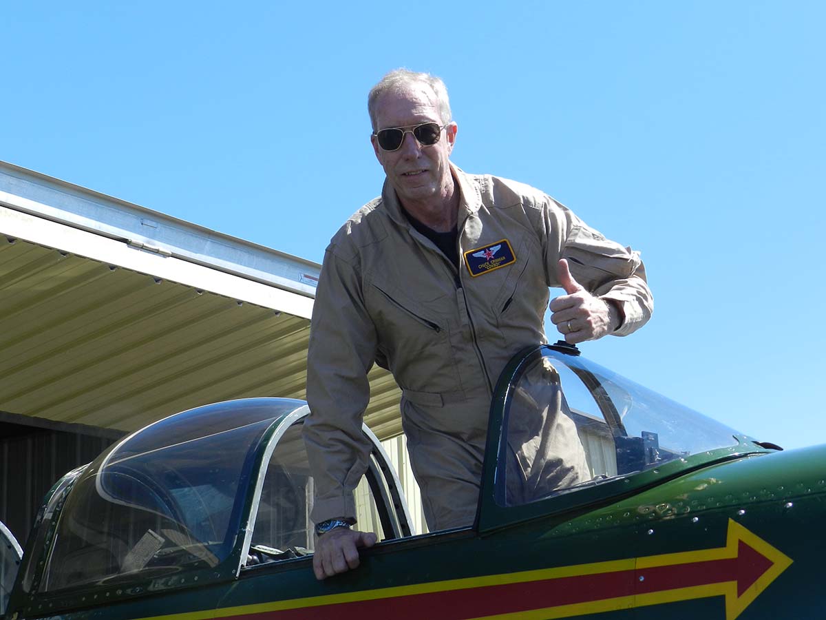 Chuck Crinnian supports Flight Safety at Embry-Riddle with planned gift Chuck Crinnian stands in cockpit of plane and give thumbs up